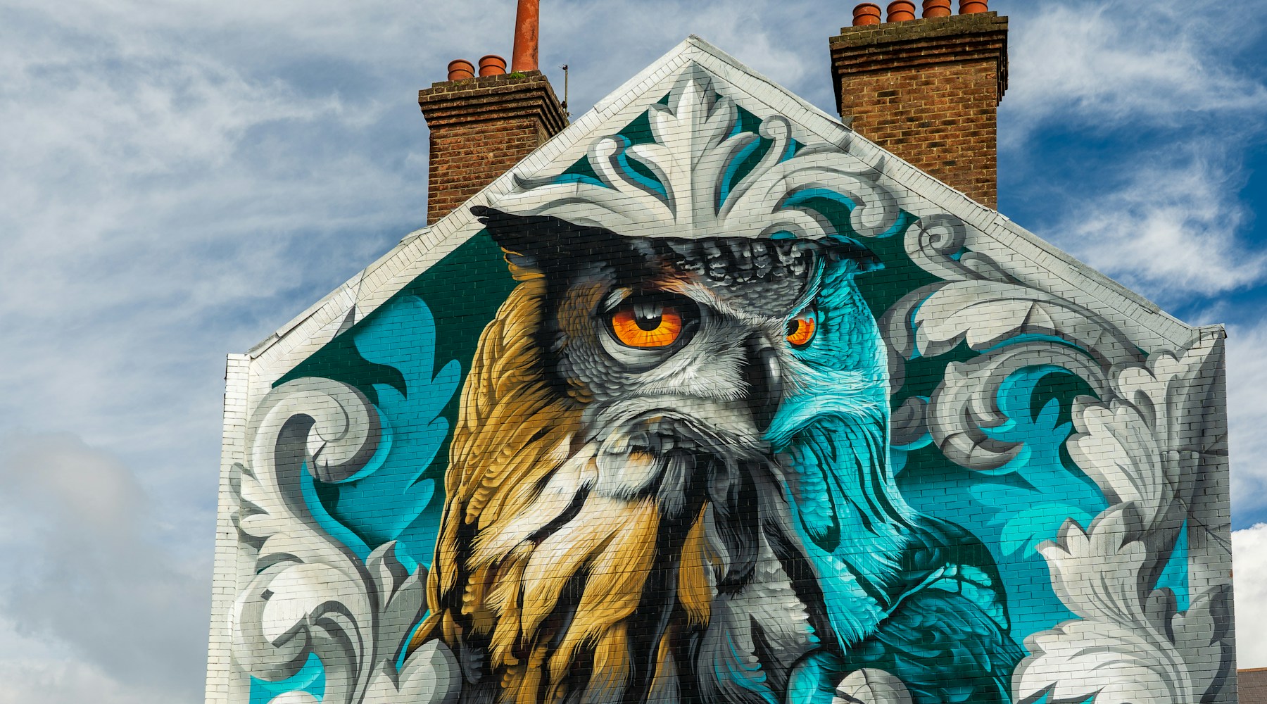Large owl mural on a weathered brick building